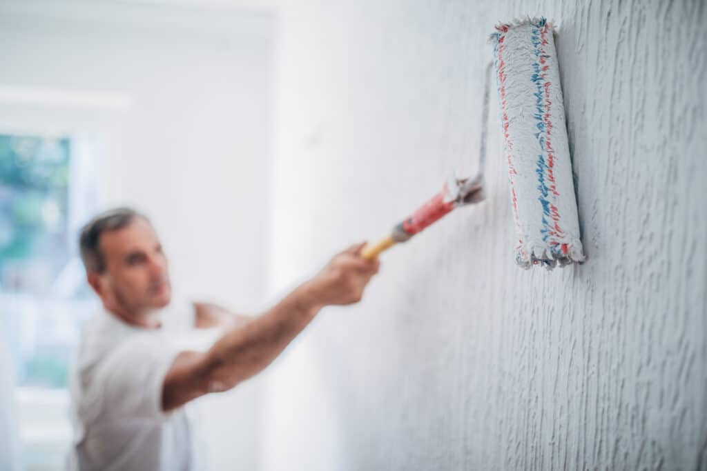 Painter man at work with a paint roller