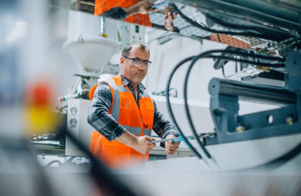 Close up shot of the CNC high-speed gun-drill machine drilling the water channel of injection mould cutting the parts with oil coolant method and simultaneous cooling in a metal manufacturing factory.